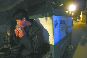 快遞哥抽空吃兩口東西。本報(bào)記者 李剛 攝